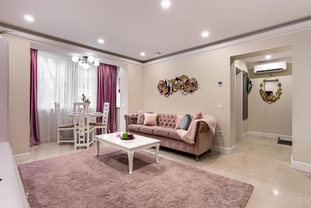 a living room with a couch and a table at Sika DeLuxe Apartment in Arad