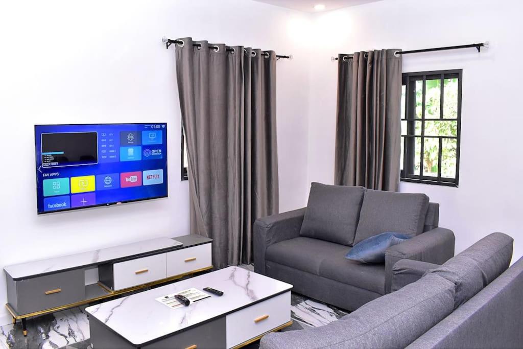 Les 9 Plurielles T 2 KPALIME KOUMA KONDA في Kpalimé: غرفة معيشة مع أريكة وتلفزيون