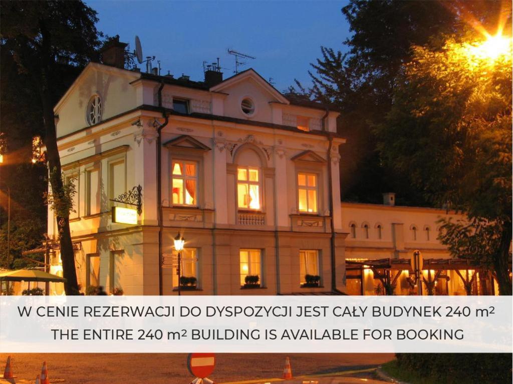 a building with a sign in front of it at night at Dom Pugetów in Krakow