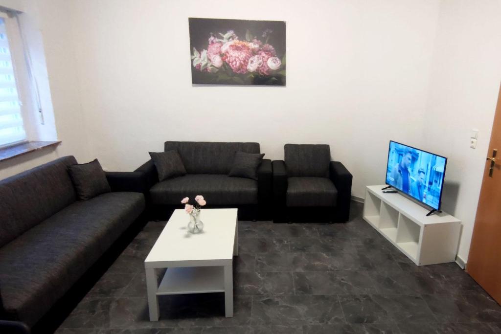 a living room with a couch and a tv at Ferienwohnung in zentraler Lage in Frechen