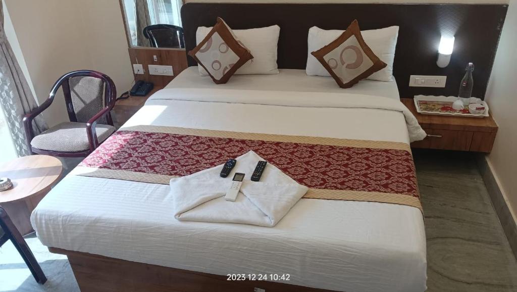 una camera da letto con un grande letto con una croce sopra di HOTEL SJ PRIDE INN a Bhubaneshwar