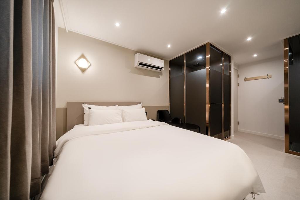 a bedroom with a large white bed and a closet at Baron De Hotel in Seoul
