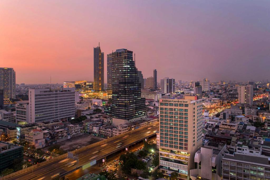 Hilton Garden Inn Bangkok Silom في بانكوك: اطلاله على مدينه بالليل بالمباني