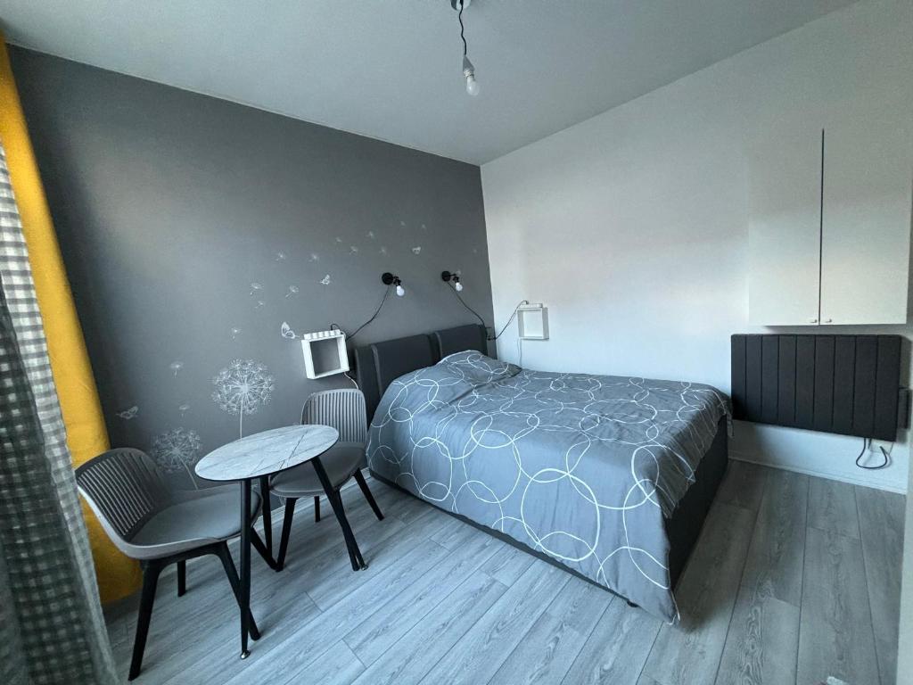 Schlafzimmer mit einem Bett, einem Tisch und Stühlen in der Unterkunft Studio à 7 min du métro Le Kremlin-Bicêtre - proche Paris in Villejuif