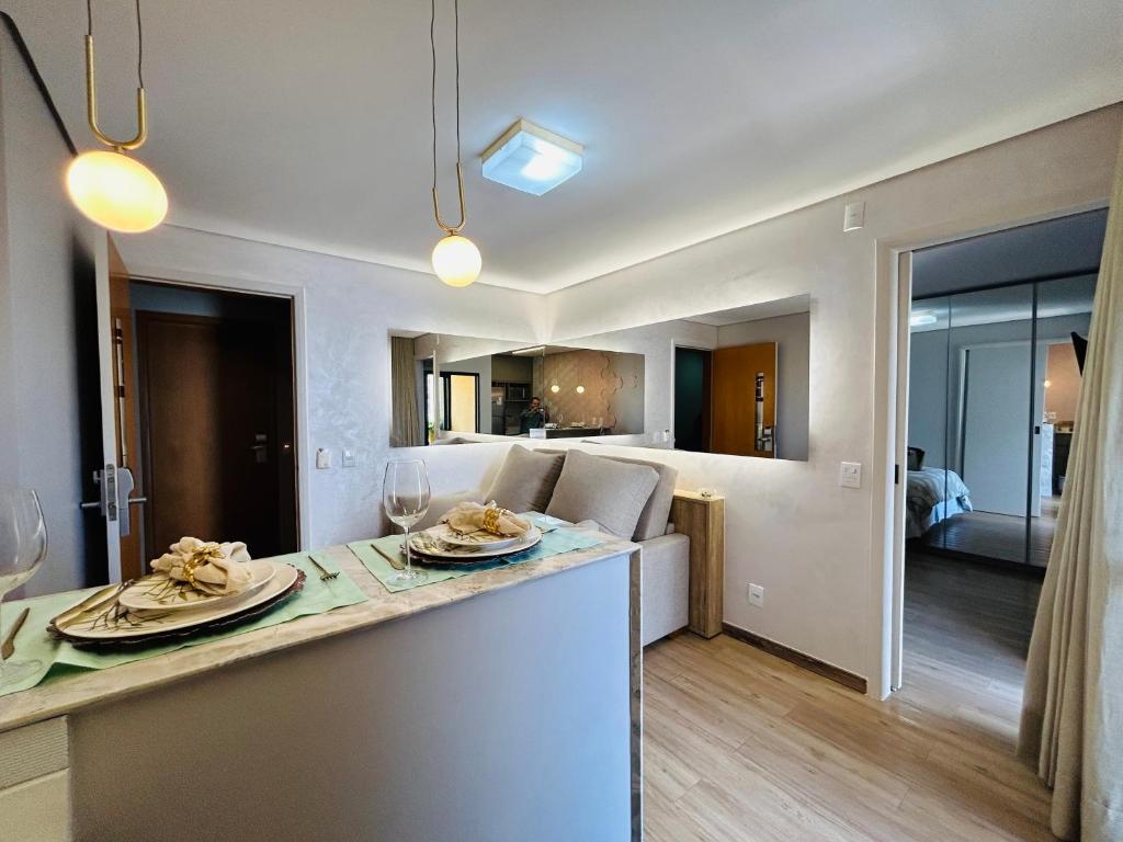 uma cozinha e sala de estar com um balcão e uma sala de estar em Flat aconchegante em Goiânia