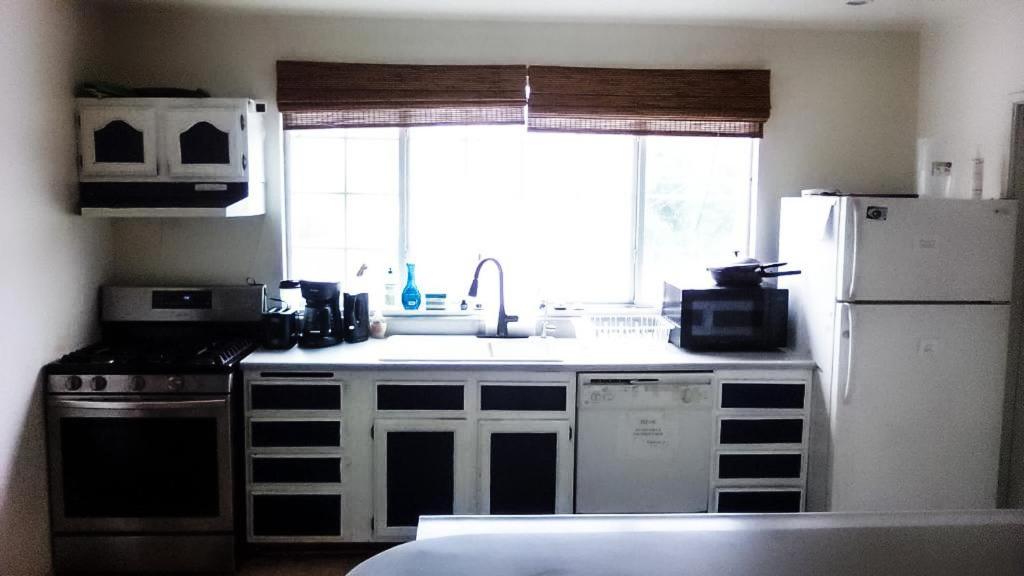 een keuken met een wastafel, een koelkast en een raam bij Robertson's Place Like Home in Los Angeles