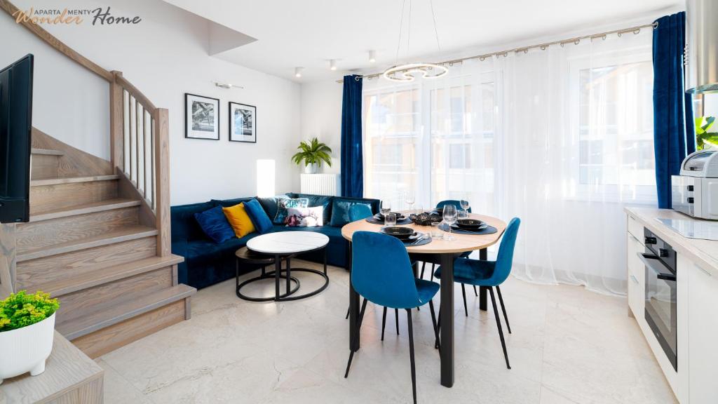 a kitchen and dining room with a table and blue chairs at Wonder Home - Apartamenty z widokiem na góry, blisko wyciągów, szlaków turystycznych i restauracji in Karpacz