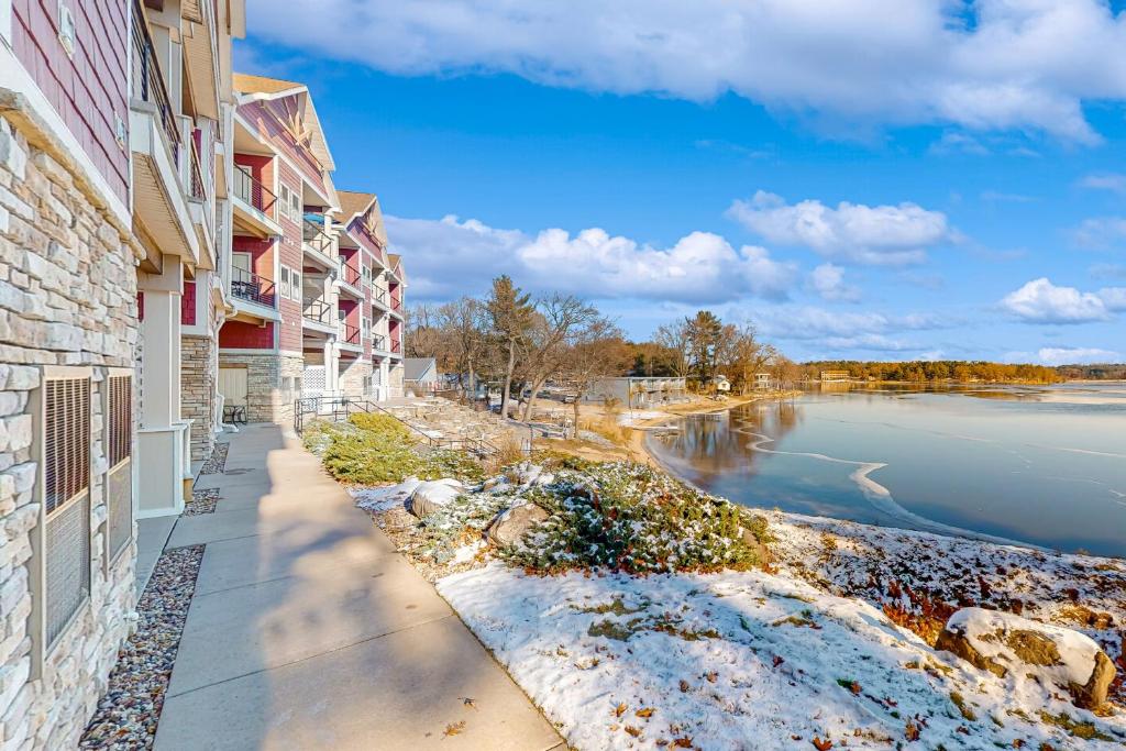 a walkway between two buildings next to a body of water at Delton Grand Resort in Wisconsin Dells