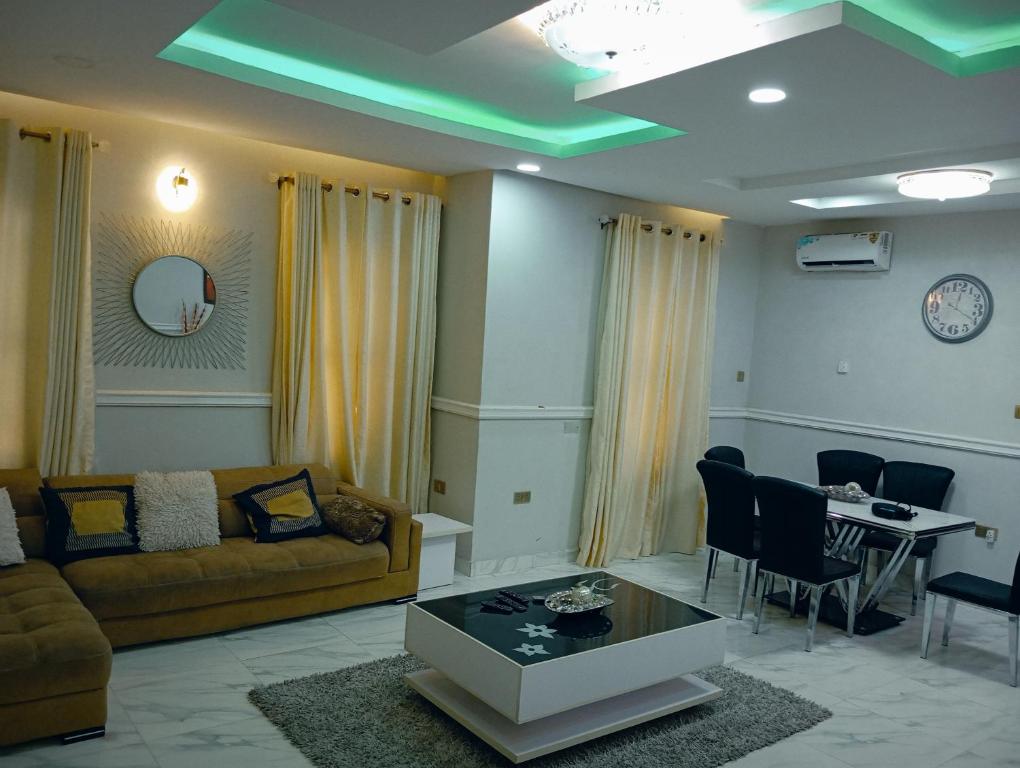 uma sala de estar com um sofá e uma mesa em Frontline Homes & Suites 3bedroom Apartment em Lekki