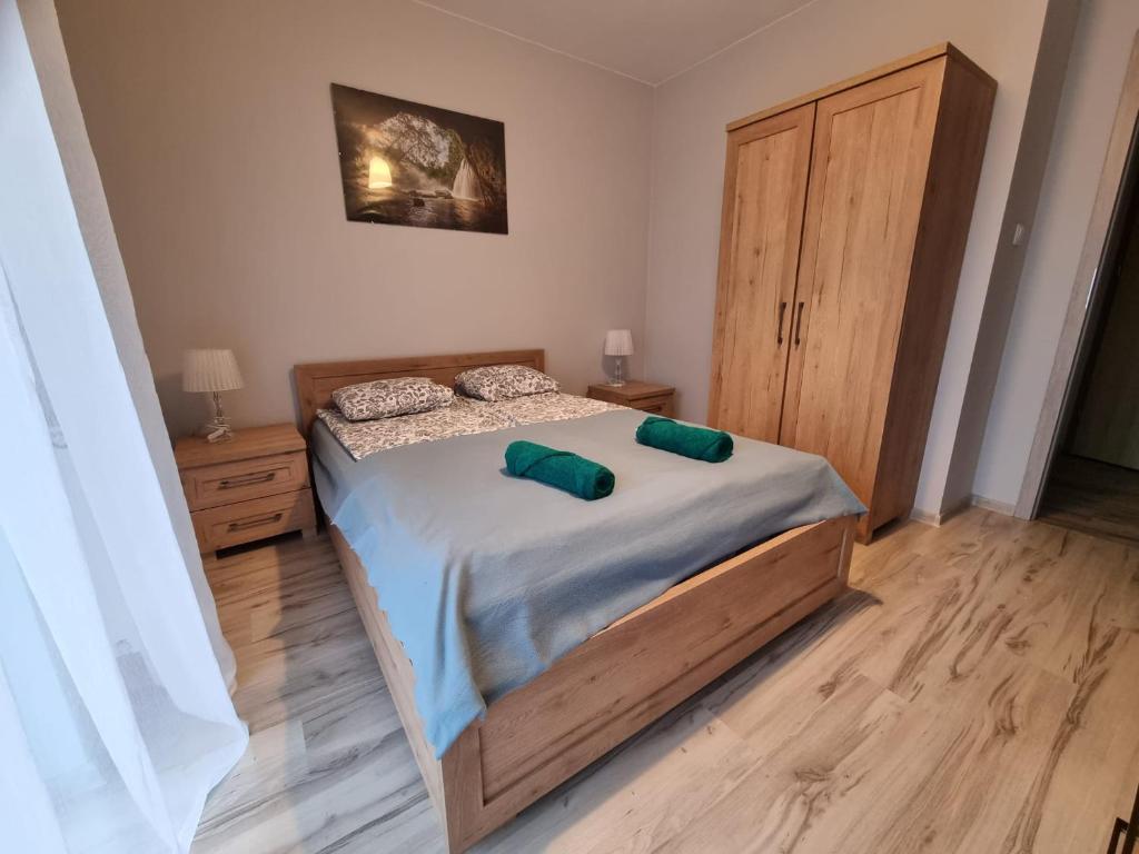 um quarto com uma cama com duas almofadas verdes em Apartament Sami Swoi em Kolobrzeg