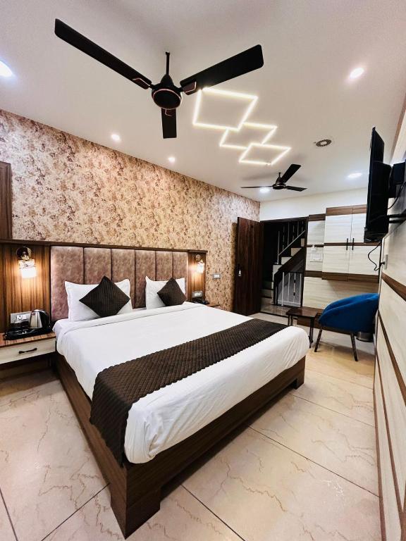 Schlafzimmer mit einem großen Bett und einem Deckenventilator in der Unterkunft HOTEL MONGA 5 Minutes From Golden Temple in Amritsar
