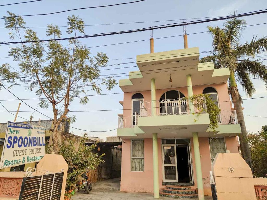 a pink house with a sign in front of it at Hotel Spoonbbill in Bharatpur