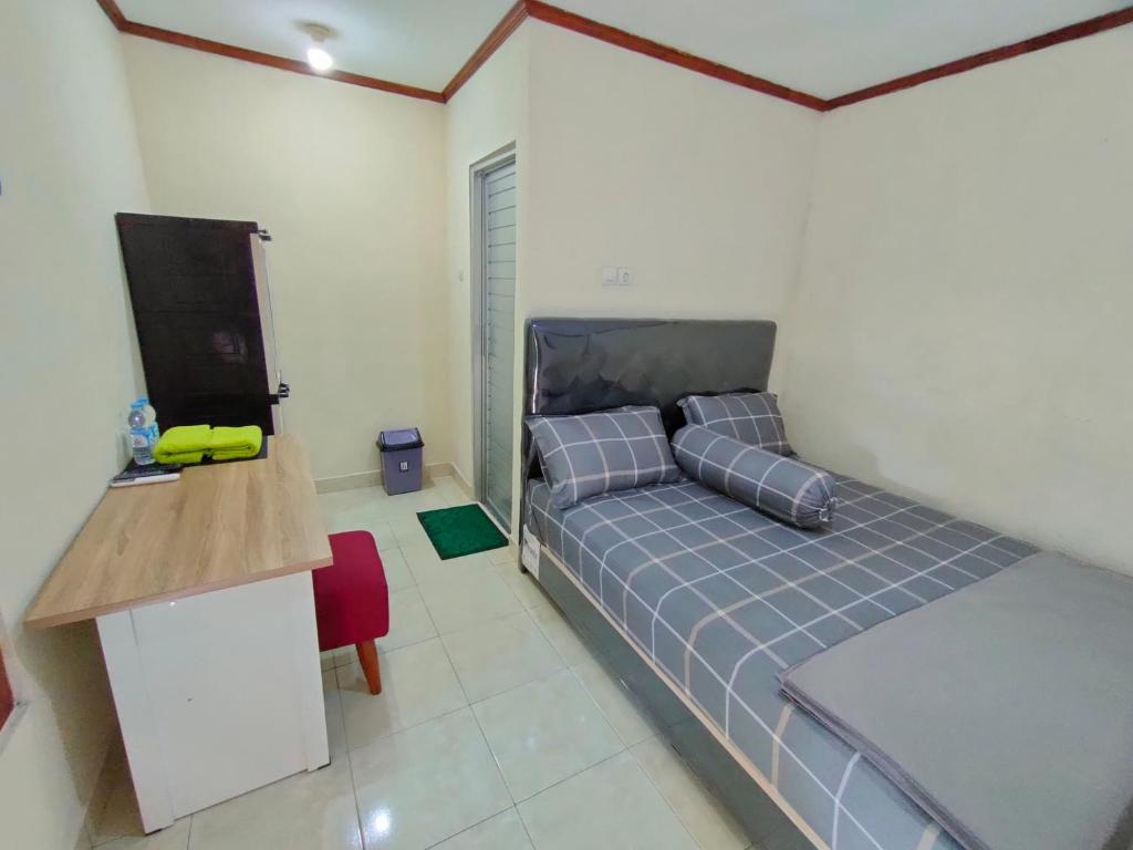 1 dormitorio con 1 cama, escritorio y TV en LAISSYA GUEST HOUSE YOGYAKARTA en Yogyakarta