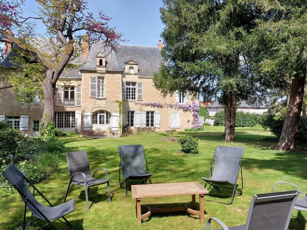 un grupo de sillas y una mesa frente a una casa en Manoir du Bellay en Montreuil-Bellay