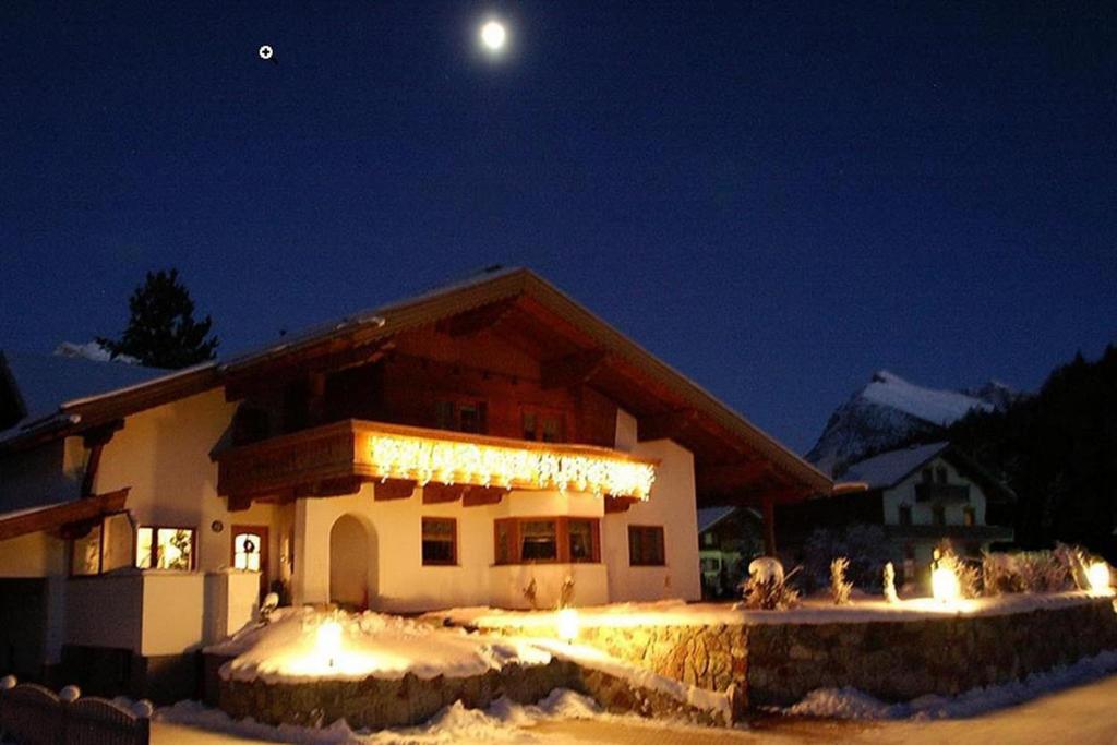 沙爾尼茨的住宿－Ferienwohnung Leismüller，夜晚雪中灯火通明的房子