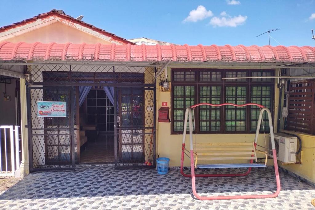 ein Gebäude mit einer Bank davor in der Unterkunft Semarak Homestay in Baling