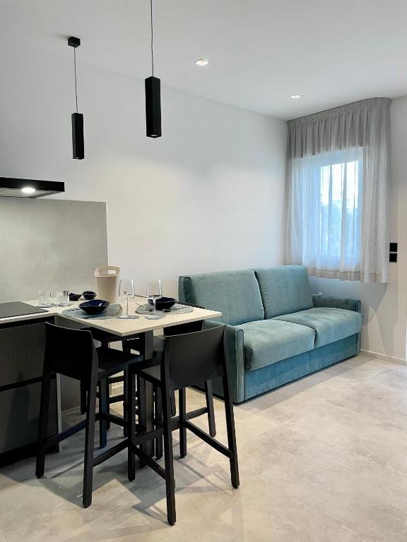 uma sala de estar com um sofá azul e uma mesa em Rondinella Suite em Lignano Sabbiadoro