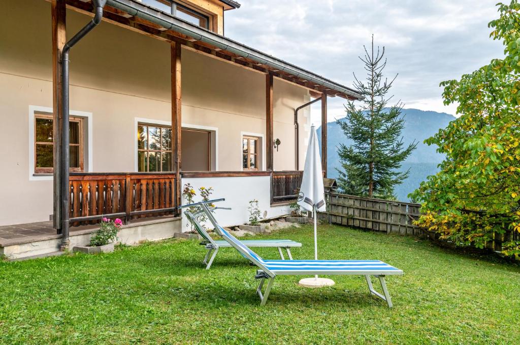 a house with a chair and an umbrella on the lawn at Apartment Funtnatsch in Laion