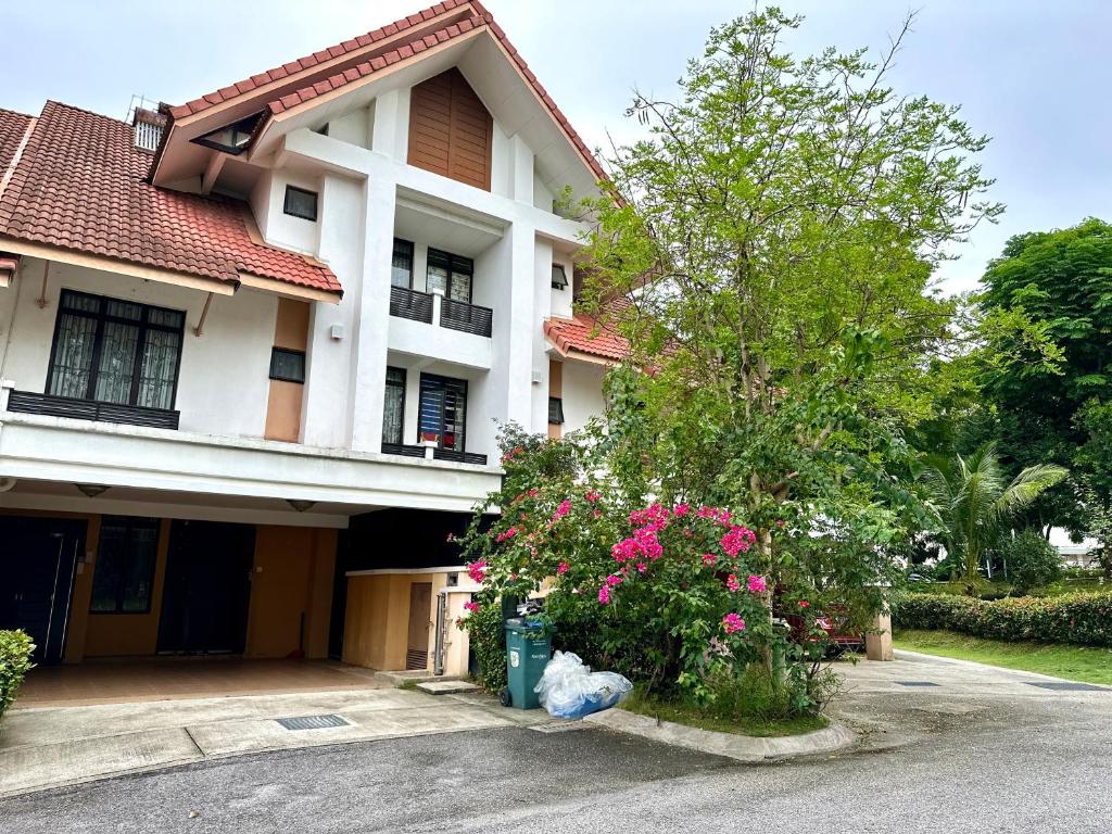 dom z różowymi kwiatami przed nim w obiekcie FamilyHaven at Presint 18 by Elitestay [5Rooms] w mieście Putrajaya