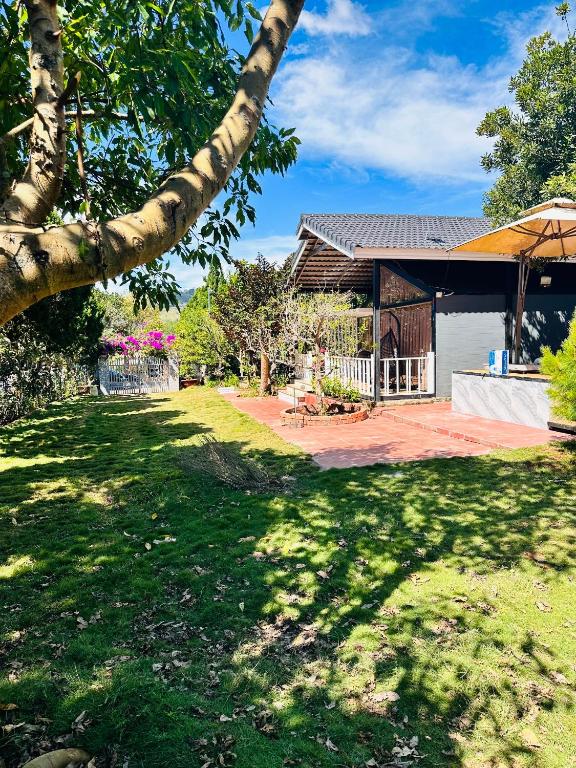 una casa con un gran patio con un árbol en Mongo Garden en Dalat