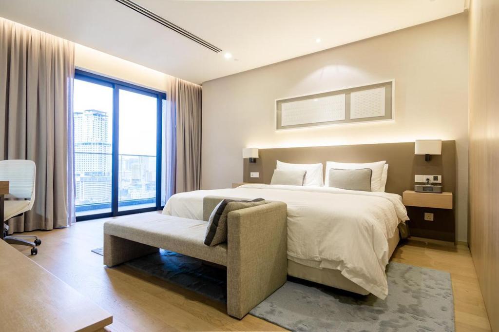 a bedroom with a large bed and a chair at 188 suites By Seng Home in Kuala Lumpur