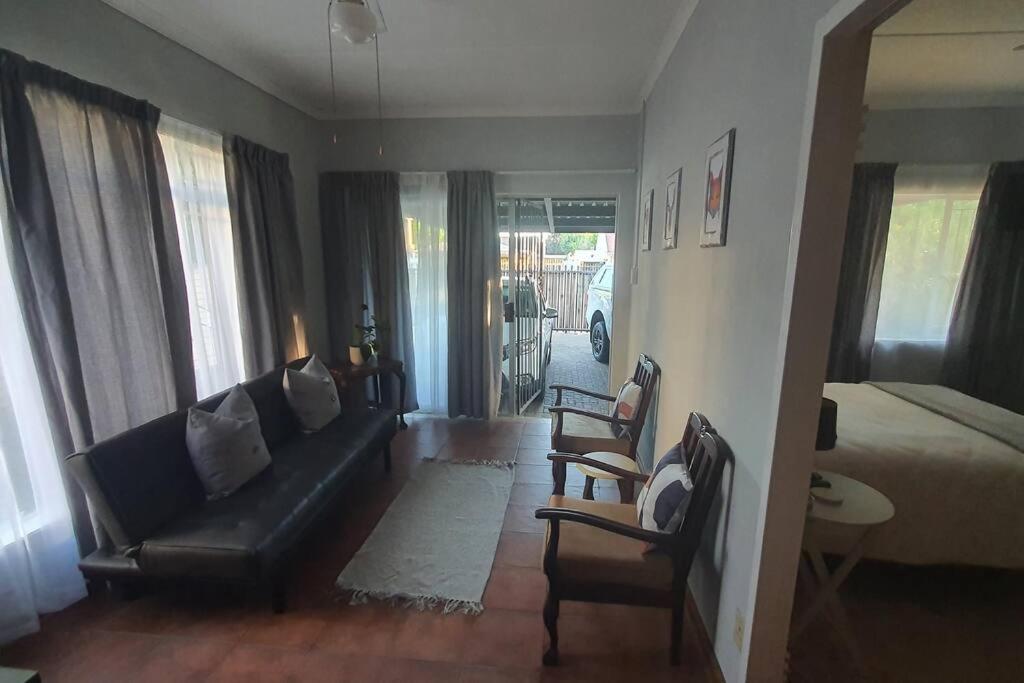 a living room with a couch and a bed at Stay at the Ridge in Bloemfontein