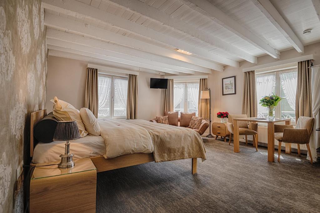 a bedroom with a large bed and a living room at Bariseele B&B in Bruges