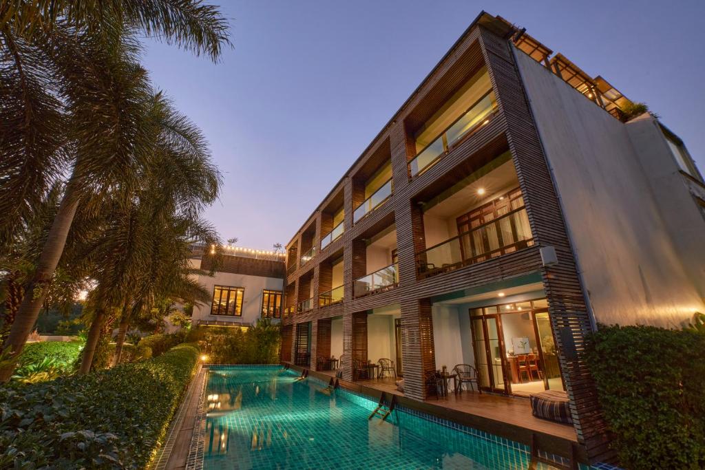 an exterior view of a building with a swimming pool at The Bihai Hua Hin in Hua Hin