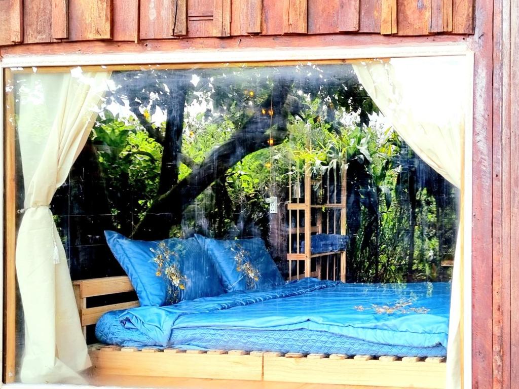 ein Fenster mit einem Bett in einem Zimmer in der Unterkunft Homestay Vườn Trái Cây Nhiệt Đới VÔ ƯU GARDEN in Bảo Lộc