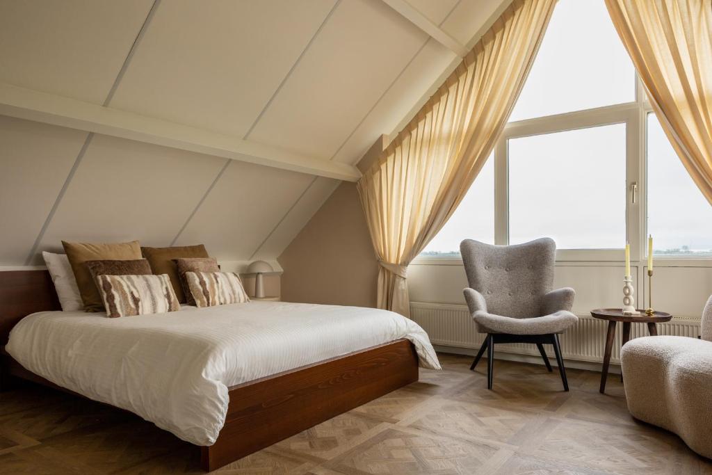 a bedroom with a bed and a chair at B&B Giethoorn in Giethoorn