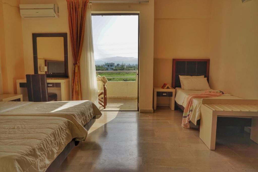 a hotel room with two beds and a large window at GOLDEN SUN in Vrachati