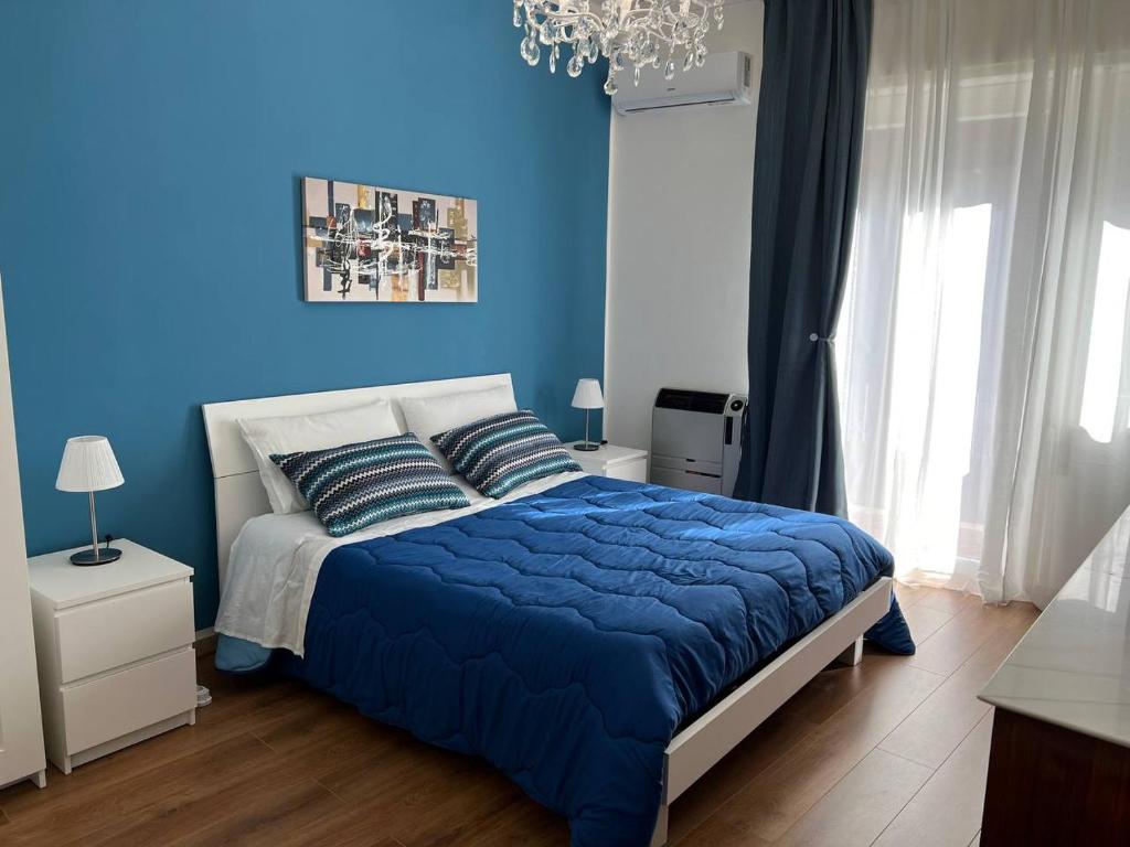 - une chambre bleue avec un lit et un mur bleu dans l'établissement Gioia di Casa - Appartamento, à Paterno