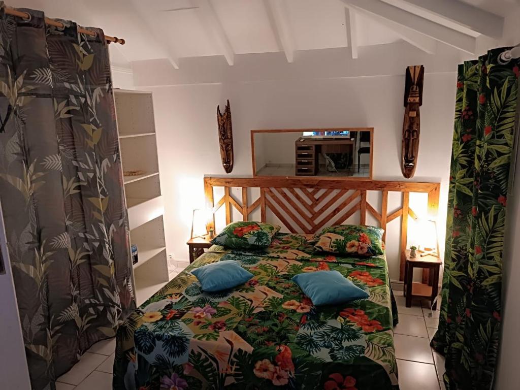 a bedroom with a bed with two pillows on it at La Kaza Tresor - Joli appartement T2 et spa privé in Sainte-Anne