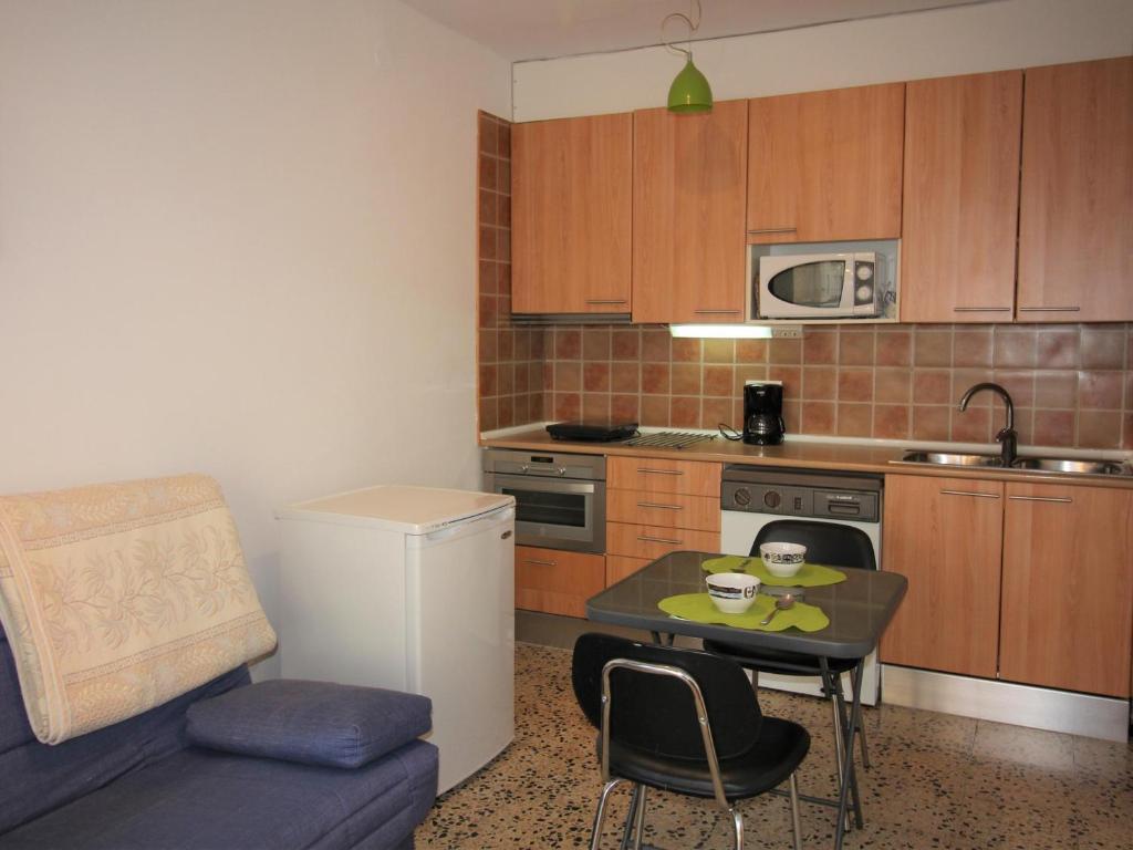 una pequeña cocina con una mesa pequeña y una silla en Apartamento Roses, 1 dormitorio, 4 personas - ES-258-61, en Roses