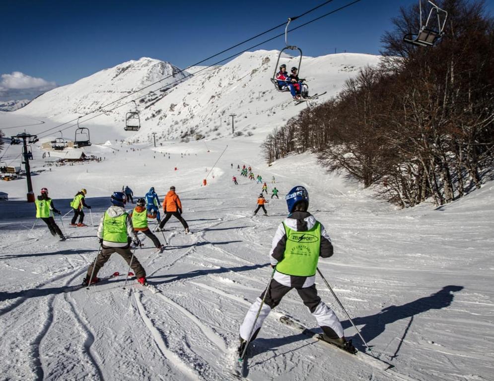 un grupo de personas esquiando por una pista de esquí en Campo Felice Apartment, en Collimento