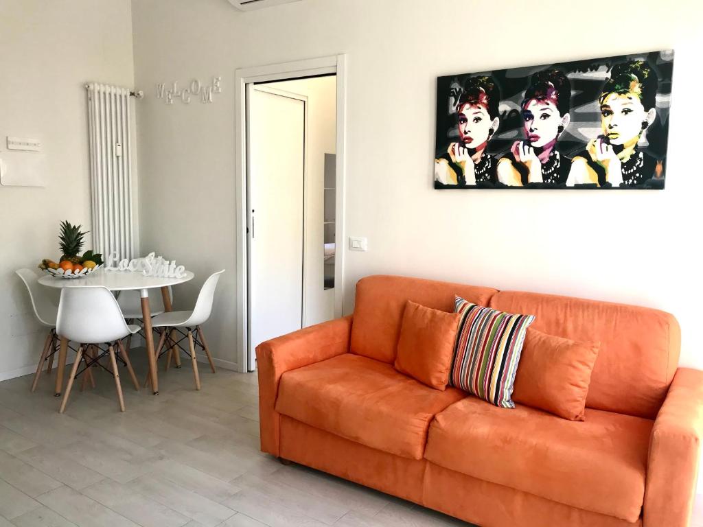 een woonkamer met een oranje bank en een tafel bij Suite Locchi. Vicino Tramvia/Careggi/Meyer in Florence