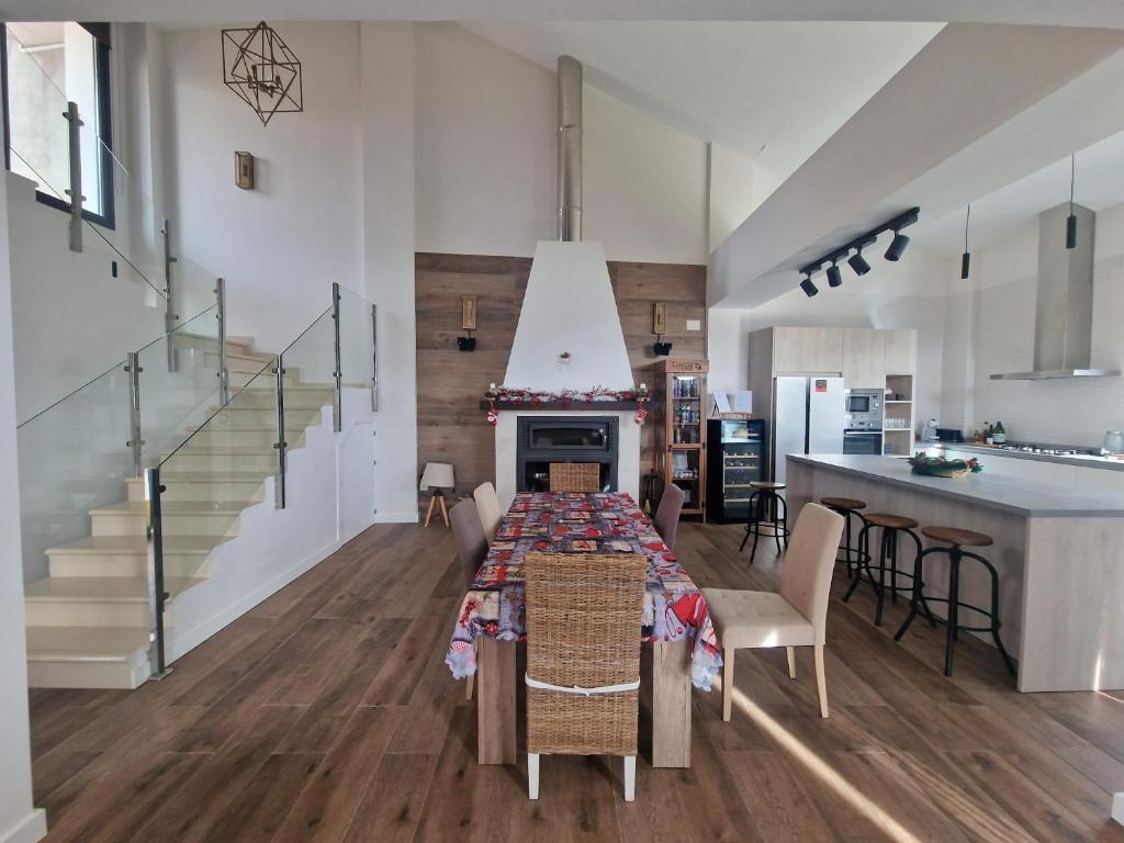 a kitchen and living room with a dining room table and a staircase at Casa Juliana in Herencia