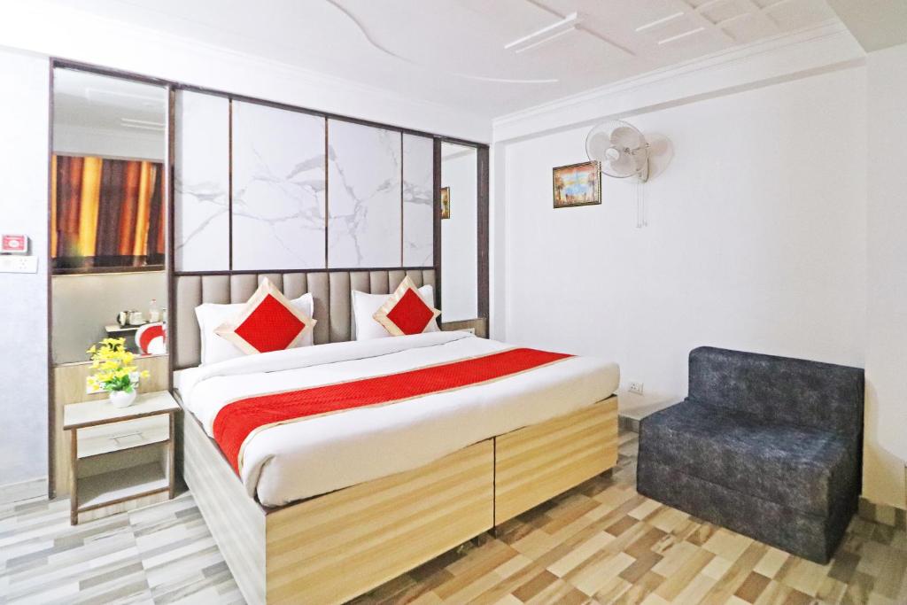 a bedroom with a bed and a chair at Hotel Clink Stay Near Delhi IGI Airport in New Delhi