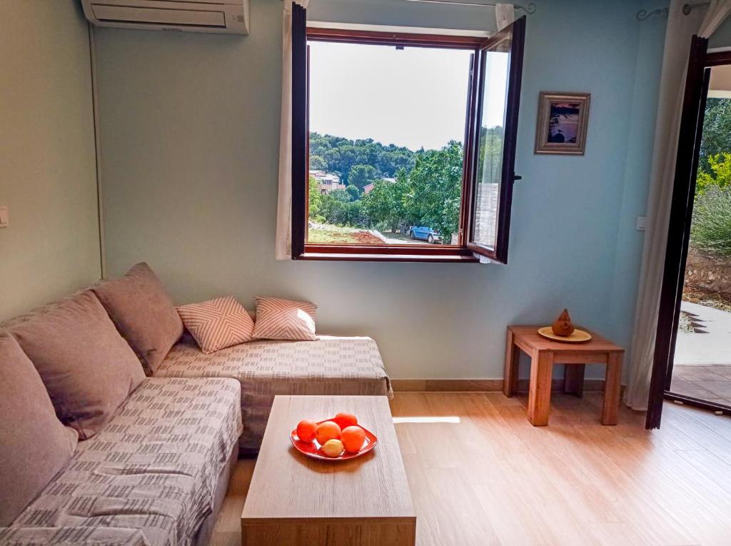 una sala de estar con sofá y un bol de fruta en una mesa en Apartment Rosemary en Vinkuran