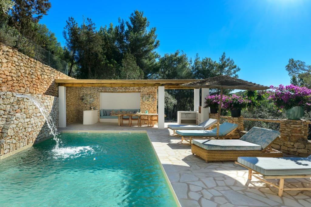 una piscina con patio, mesa y sillas en Villa Mediterraneo en Sant Carles de Peralta