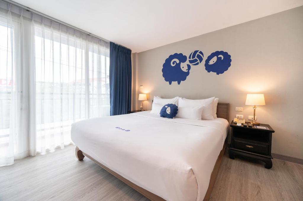 a bedroom with a large bed with blue signs on the wall at Kokotel Krabi Ao Nang in Ao Nang Beach