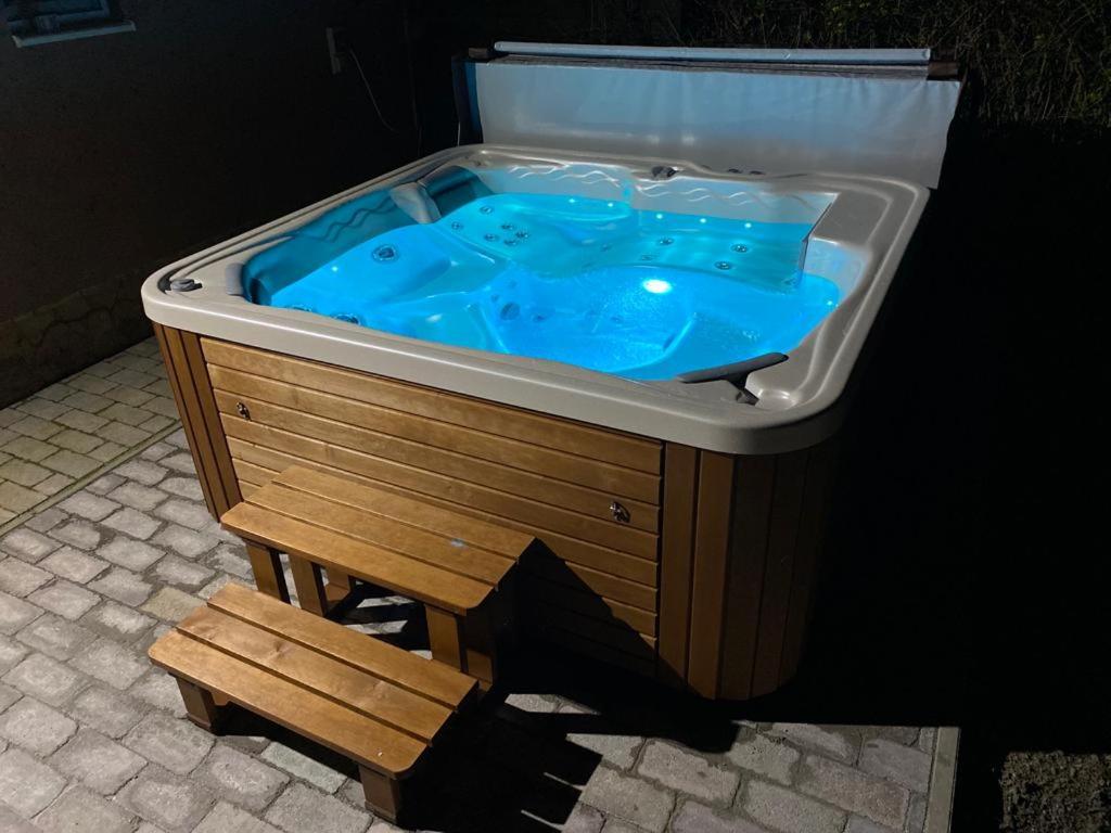 a hot tub with a wooden bench in front of it at Vadszőlő Apartman in Balatonmáriafürdő