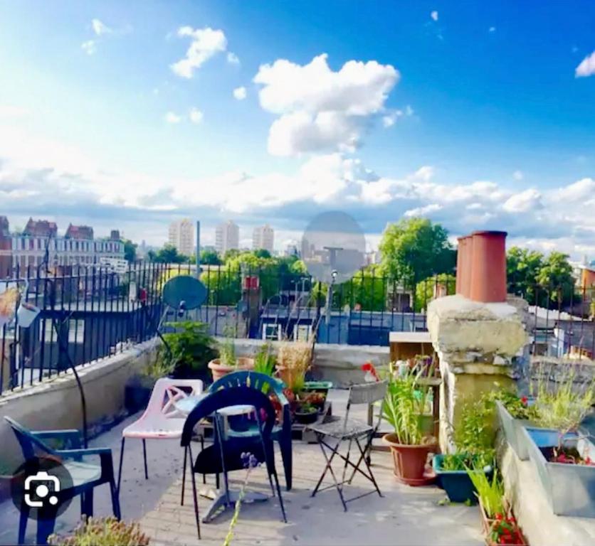 un patio avec des chaises et des plantes sur le toit dans l'établissement 2 Bedroom Flat London,Sleeps 6, Top Floor, Roof Terrace, Next to Brixton Underground Station, à Londres