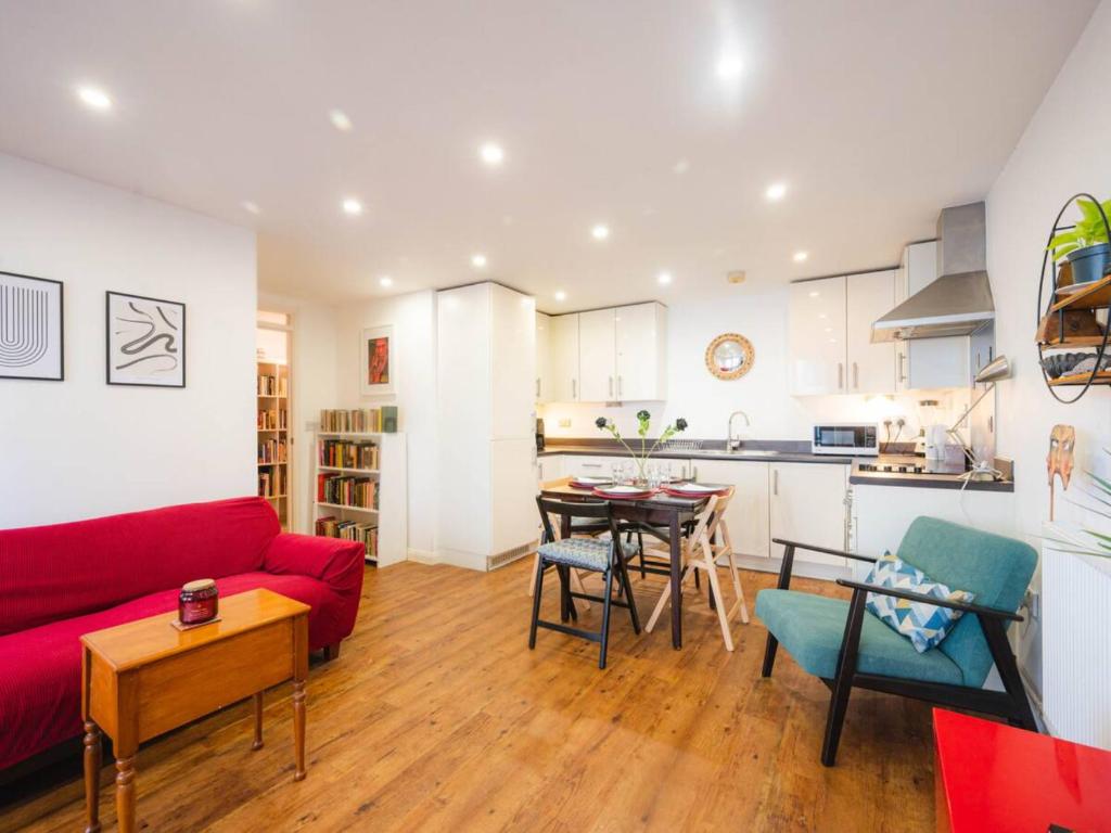 uma sala de estar com um sofá vermelho e uma mesa em Pass The Keys Modern 2-Bed Apartment with Private Balcony, Near Dalston Junction Station - Ideal Urban Retreat! em Londres