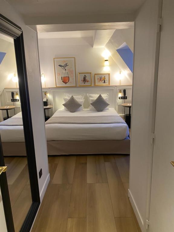 1 dormitorio con 1 cama grande y espejo en XO Hotel Paris, en París