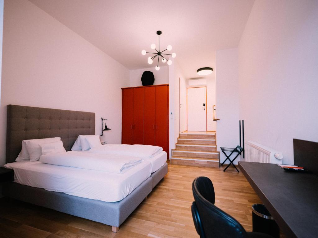 um quarto com uma cama, uma mesa e cadeiras em GUESTHOUSE RIEGERSBURG - Das Haus der guten Geister em Riegersburg