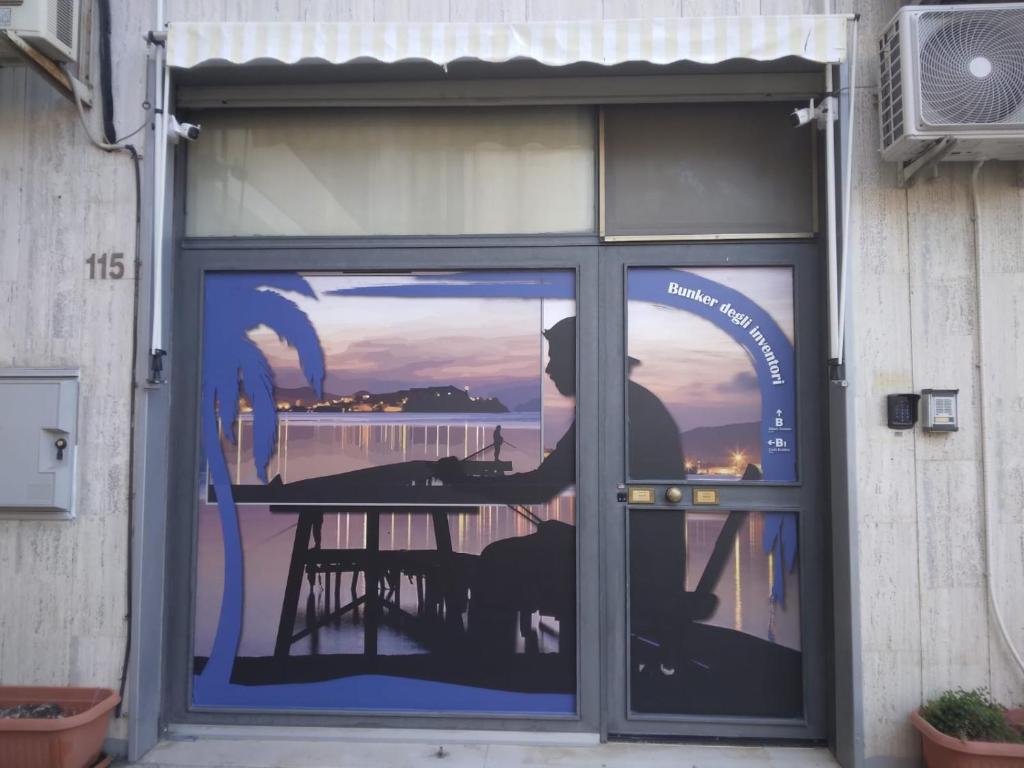 una ventana con una foto de un hombre sentado en una mesa en Bunker degli inventori, en Foggia