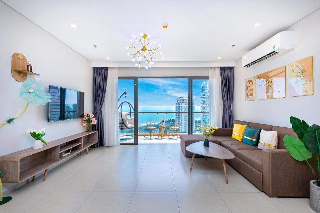 a living room with a couch and a large window at The Sóng Vũng Tàu Apartment - 28 Thi Sách Phường Thắng Tam in Vung Tau