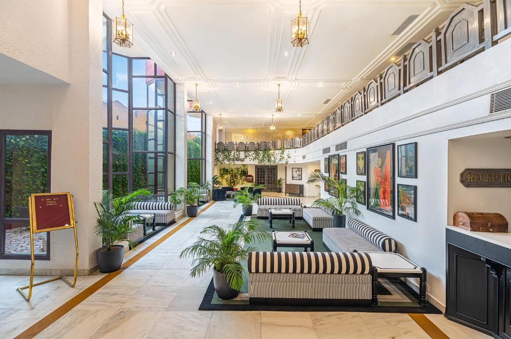 a lobby with couches and plants in a building at Rajdarshan - A Lake View Hotel in Udaipur in Udaipur