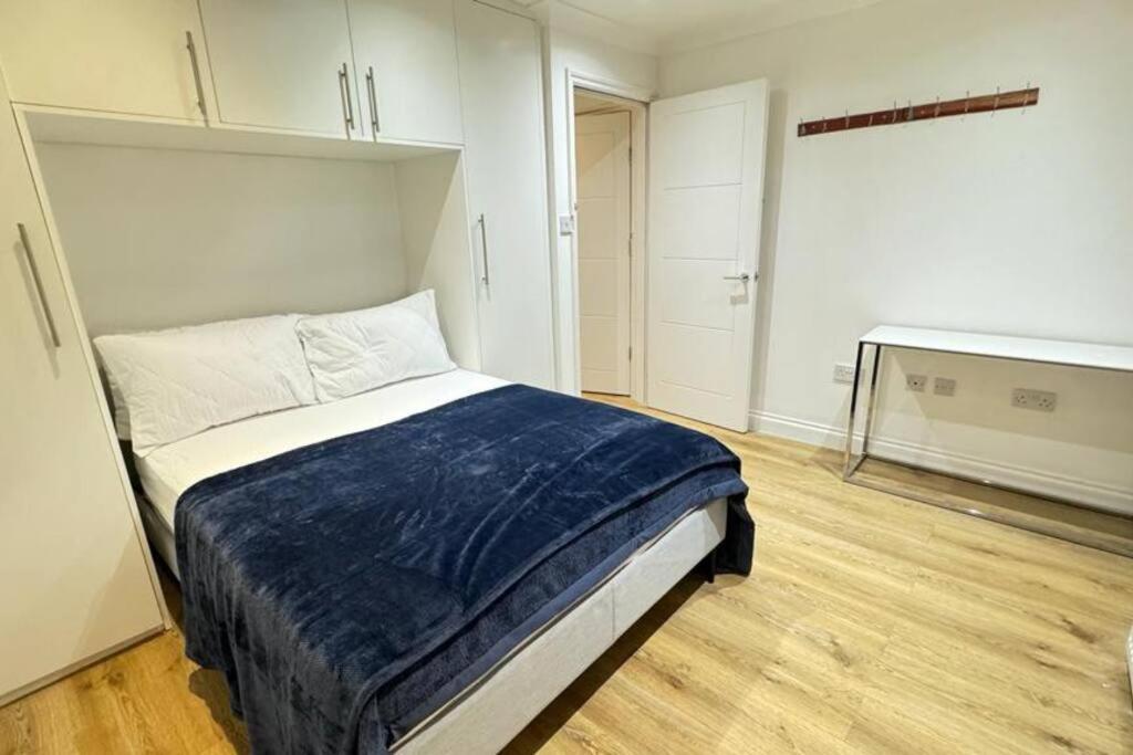 Un dormitorio con una cama con una manta azul. en New Croydon Near Waddon Station!, en Croydon
